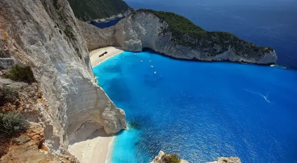 Widok na Navagio, słynną zatokę wraku, z turkusową wodą i białymi klifami.