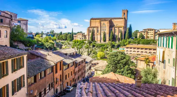 Un panorama mozzafiato di Siena, una gemma della Toscana da visitare, con la maestosa Basilica di San Domenico che domina il paesaggio urbano.