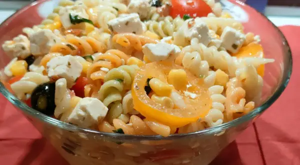 Kolorowa sałatka z makaronem fusilli, serem feta, oliwkami, kukurydzą i pomidorkami. Idealna na letnie dni.