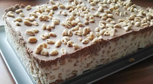 Pyszne ciasto Kinder Country na dużą blachę, z kremem i czekoladą, posypane chrupkami.