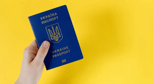 Dłoń trzyma paszport Ukrainy. Specustawa Ukraina ułatwia obywatelom Ukrainy dostęp do dokumentów.