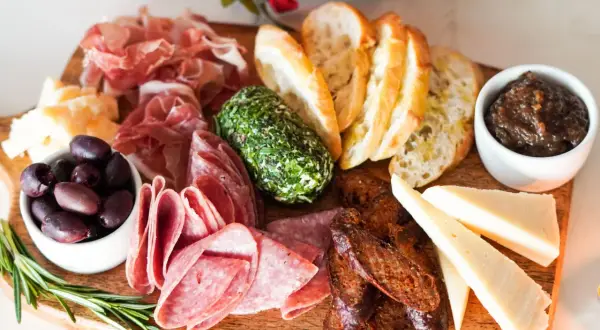 Planche apéro gourmande : charcuteries fines, fromages variés, olives, pain grillé, confiture de figues et fromage frais aux herbes. Une belle idée pour un moment convivial.