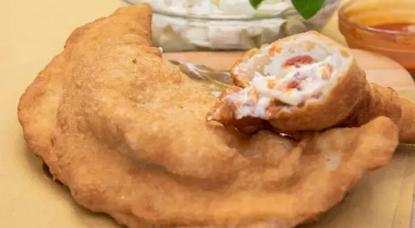 Pizza fritta napoletana: impasto dorato e ripieno cremoso con pomodoro e mozzarella. Ingredienti semplici per un gusto unico.