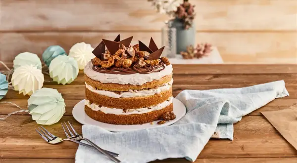 Eine köstliche Nougat Torte mit Schokoladenstücken und Nüssen, dekoriert mit einer Kordel aus Papierlaternen.