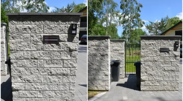 Solidne ogrodzenie z pustaków z wbudowaną skrzynką na listy i domofonem. Obok śmietniki i furtka.