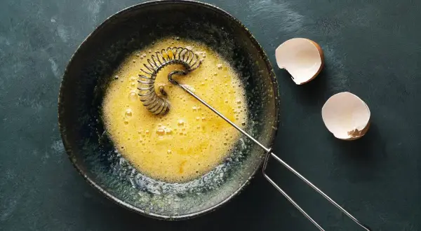 Ubite żółtka w misce, obok skorupki jajek. Idealne do omletu lub ciasta.