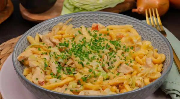 Herzhafte Spätzle mit Hähnchen und Spitzkohl, garniert mit Schnittlauch. Ein leckeres Gericht, das zeigt, wie vielseitig Spitzkohl Rezepte sein können.