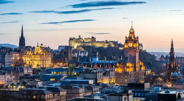Edinburgh im Oktober: Die beleuchtete Skyline mit dem Schloss und dem Scott Monument im Abendlicht.