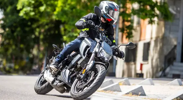 Motociclista en curva con una moto naked. Opiniones sobre la Orcal SK 01 125.