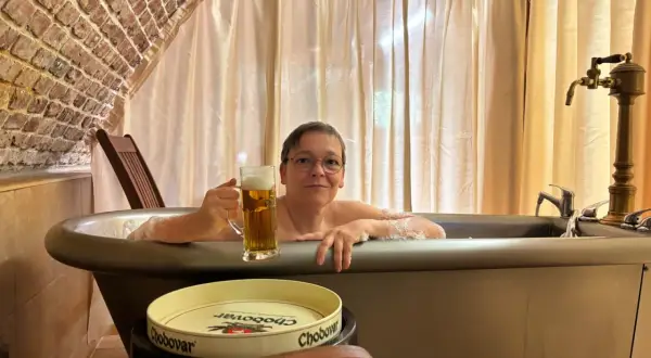 Entspannte Frau mit Bier im Bad des Chodovar Hotels.