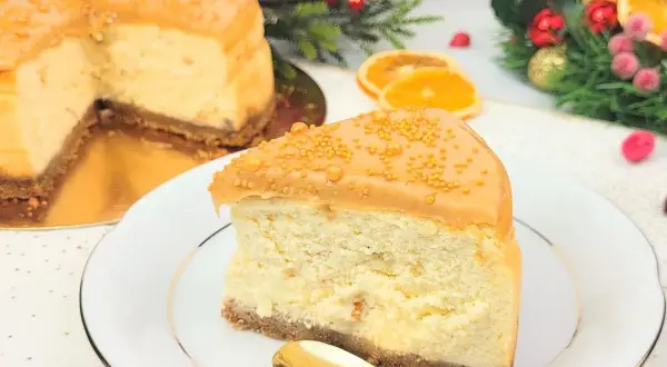 Pyszny sernik z ciasteczkami korzennymi, udekorowany karmelem i złotymi kuleczkami. Idealny na święta!