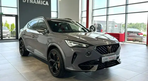 Szary Cupra samochod z czarnymi felgami stoi w salonie.