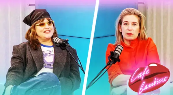 Eva Ekselius med bandana och solglasögon sitter vid en mikrofon. Bredvid henne sitter en kvinna i orange klänning.