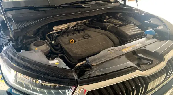 Silnik Skoda Kodiaq, widok z góry, z otwartą maską. Widać elementy silnika, reflektor i grill.