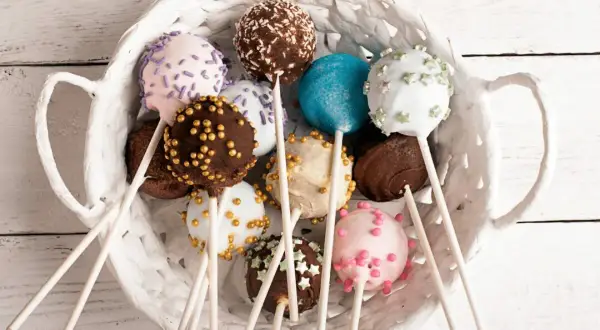 Kolorowe cake pops w białym koszyku. Idealne na imprezę, oto prosty cake pops przepis.