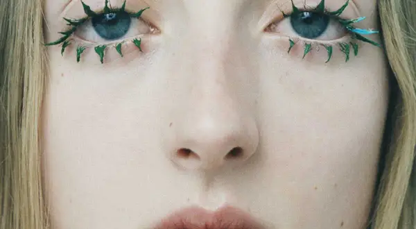 Yeux bleus aux cils verts et bleus, comme un mascara yeux qui pleurent artistiquement appliqué.