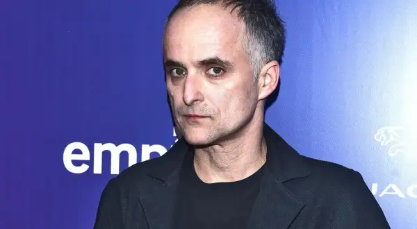 Artur Rojek, myslovitz wokalista, zamyślony, w czarnej marynarce i t-shircie z napisem.