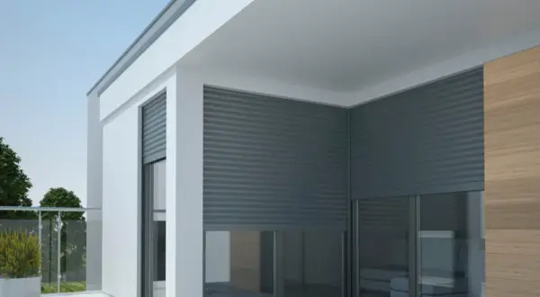 Nowoczesny budynek z ociepleniem, na którym zamontowano rolety zewnętrzne. Eleganckie i funkcjonalne rozwiązanie.