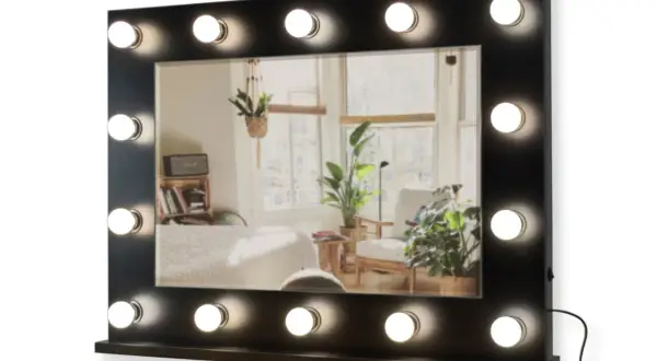 Lustro do toaletki z 16 żarówkami LED, idealne do makijażu. Odbija przytulne wnętrze z roślinami i łóżkiem.