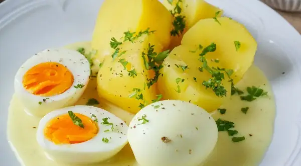 Saure Eier Rezept: Gekochte Eier und Kartoffeln in cremiger Sauce, garniert mit Petersilie. Ein einfaches und leckeres Gericht.