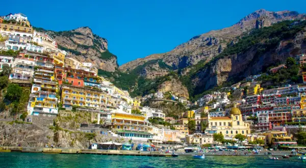 Positano, jedno z najpiękniejszych miejsc we Włoszech, z kolorowymi domami wciśniętymi w zbocze góry nad turkusowym morzem.