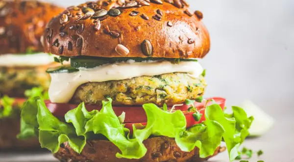 Pyszny wege burger z ziarnistą bułką, soczystą sałatą, pomidorem i kremowym sosem. Zastanawiasz się, ile kalorii ma wege burger?