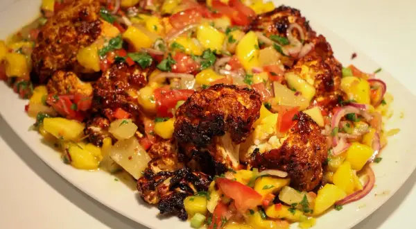 Ugnsbakad blomkål med en fräsch mangosalsa. Ett perfekt recept för en somrig middag.