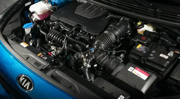 Detalle de los motores Kia, con el logo de la marca en azul brillante y componentes del motor turbo.