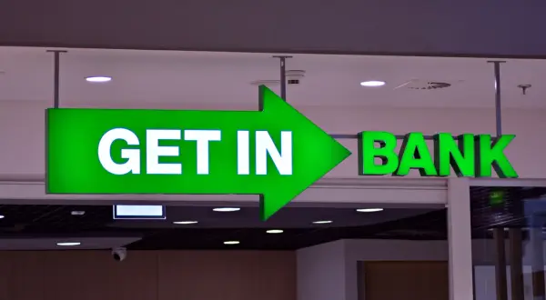 Zielony neon z napisem "GET IN BANK" i strzałką.