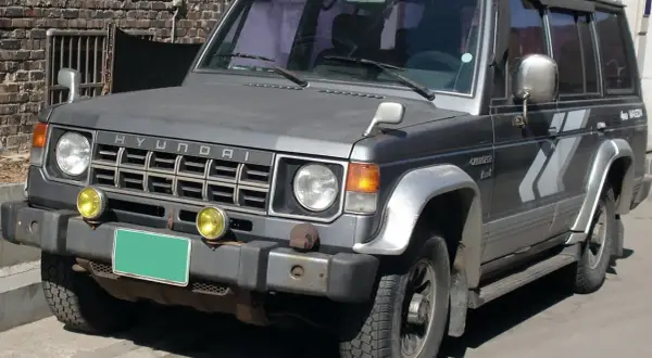 Szary Hyundai Galloper 2.5 TDI z żółtymi światłami przeciwmgielnymi i zieloną tablicą rejestracyjną.