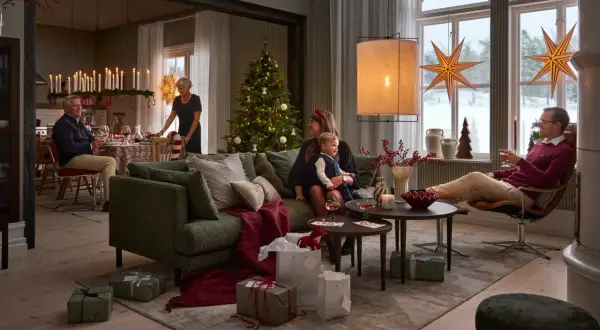 En familj samlas för en mysig jul. Julgranen är klädd, presenter ligger utspridda och ljusen lyser upp rummet.