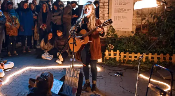 Alice Phoebe Lou spielt in Berlin vor begeistertem Publikum. Eine Lichterkette umrahmt die Bühne.
