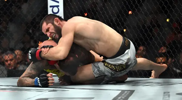 Två MMA-fighters i en intensiv kamp på mattan under UFC 311. En kämpe har överhanden och försöker säkra en submission.