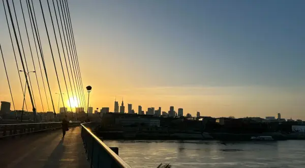 Zachód słońca nad Wisłą, widok na warszawskie **Powiśle** z perspektywy mostu.