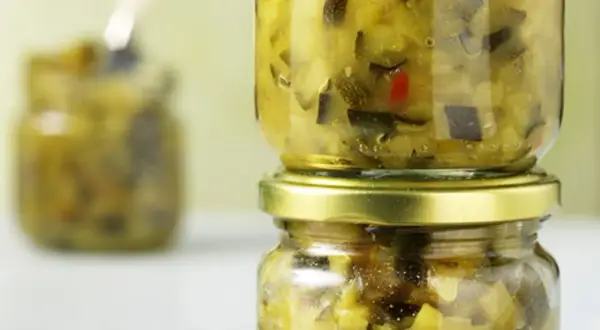 Zwei Gläser mit selbstgemachtem Zucchini-Chutney, eines auf dem anderen gestapelt.