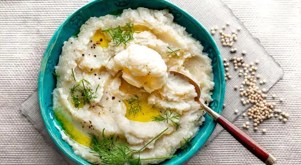 Aksamitne puree z kalafiora, polane oliwą, ozdobione koperkiem i świeżo mielonym pieprzem. Idealne jako lekki dodatek.