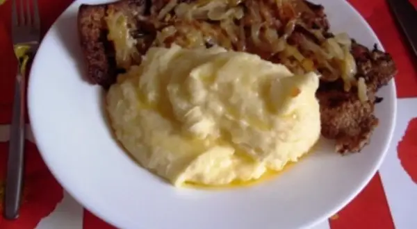 Herzhaft gebratene Leber mit Zwiebeln und cremigem Kartoffelbrei auf einem Teller. Ein Klassiker, der Appetit macht.