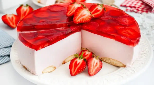 Najdelikatniejszy sernik z mascarpone na zimno, ozdobiony galaretką i świeżymi truskawkami. Idealny deser na lato.