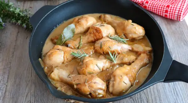 Jamoncitos de pollo guisados en una sartén, con hierbas aromáticas y una salsa cremosa. ¡Un plato casero delicioso!