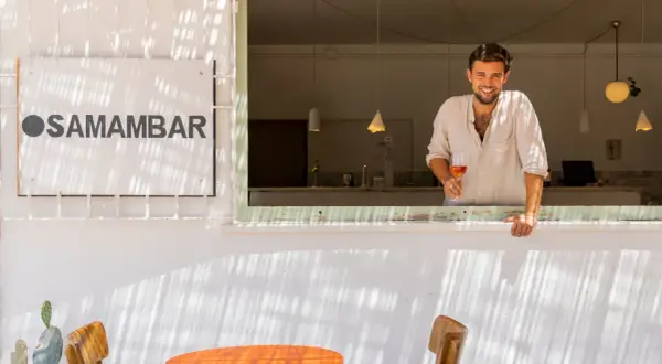 Hombre sonriente con copa de vino rosado en Samamabar, un lugar ideal para comer en Rodalquilar.