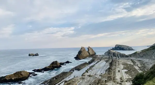 Acantilados de Liencres con formaciones rocosas únicas y el mar Cantábrico.