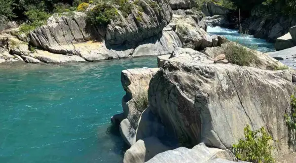 Aguas turquesas fluyen entre rocas erosionadas. Un lugar idílico para leer reseñas de la poza del molino y disfrutar de la naturaleza.