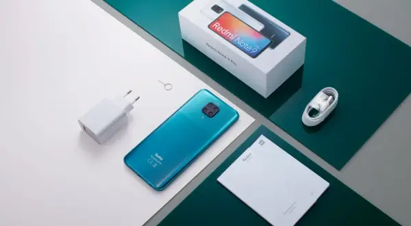 Zestaw Xiaomi Redmi Note 9 Pro: turkusowy telefon, ładowarka, kabel, instrukcja i pudełko. Aparat tego modelu robi świetne zdjęcia.
