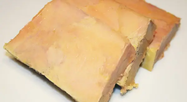Trois tranches de terrine de foie gras, préparées avec une presse, sur fond blanc.