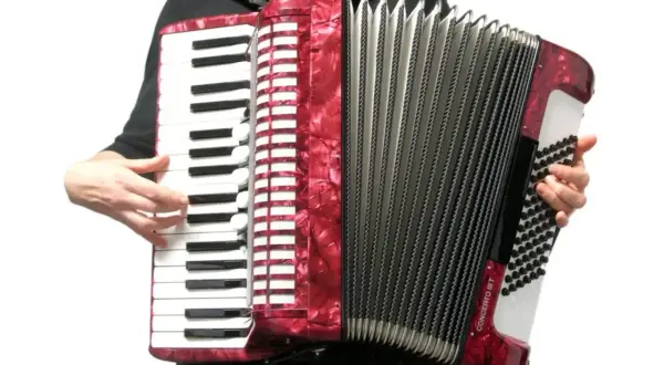 Czerwony akordeon instrument, z klawiaturą i miechem, gotowy do gry.
