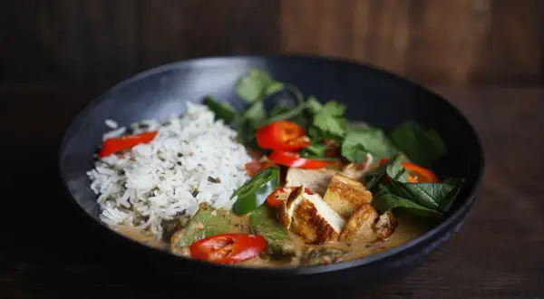 Schüssel mit Reis, Tofu, Erbsen, Chili und Koriander. Ein authentisches Thai Curry Rezept original.