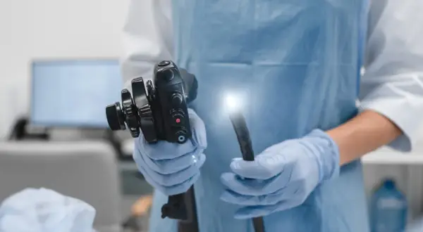Lekarz w rękawiczkach trzyma endoskop. To narzędzie, które pomaga najlepszym onkologom od raka jelita grubego w diagnostyce.
