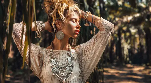 Kobieta w koronkowej sukience i bogatej biżuterii, uosobienie stylu boho. Jej stylizacje to kwintesencja wolności i natury.
