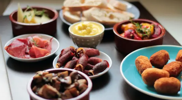 Vielfalt an Tapas: Käse, Schinken, Pilze, gefüllte Datteln im Speckmantel, Kroketten und Brot. Ein Fest für die Sinne!
