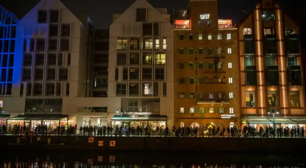 Wieczorem na Wyspie Spichrzów tętnią życiem restauracje, a tłumy spacerują nad wodą.